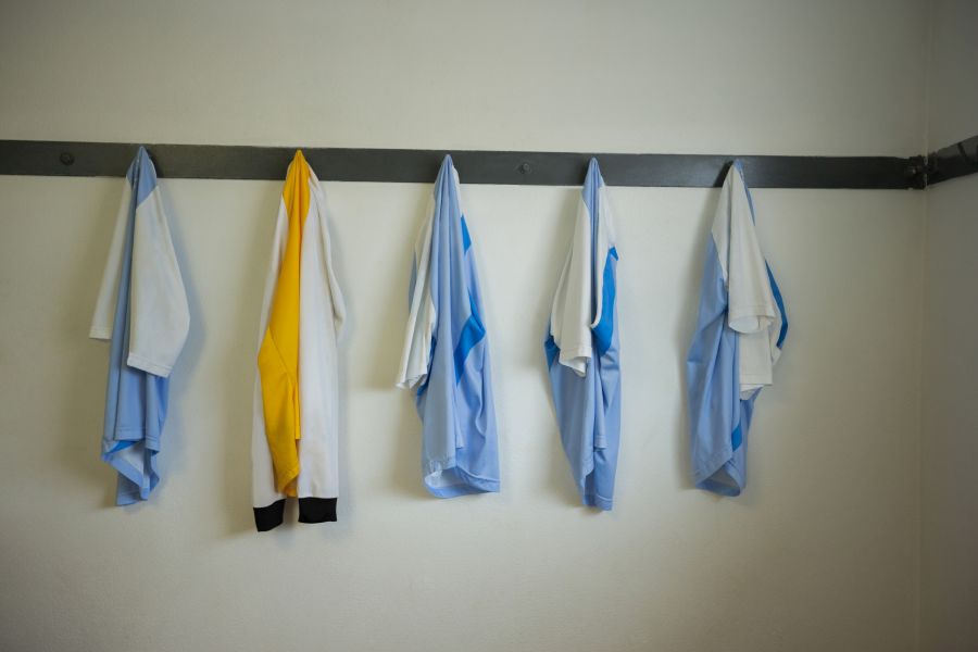 Fußballtrikots von Kinder an Haken in einer Umkleidekabine